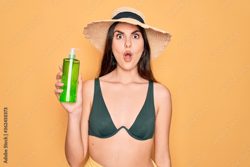Φωτογραφία Young beautiful girl wearing swimwear bikini and summer hat holding alove vera s