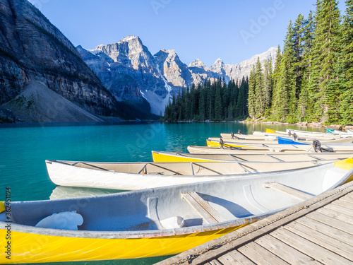 view of a turquoise lake in the morning with canoe in the front
