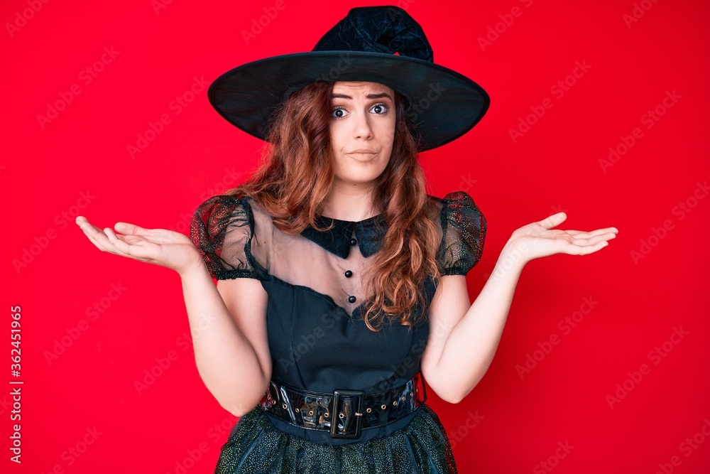 Young beautiful woman wearing witch halloween costume clueless and confused with open arms, no idea and doubtful face. Young beautiful woman wearing witch halloween costume clueless and confused with open arms, no idea and doubtful face.