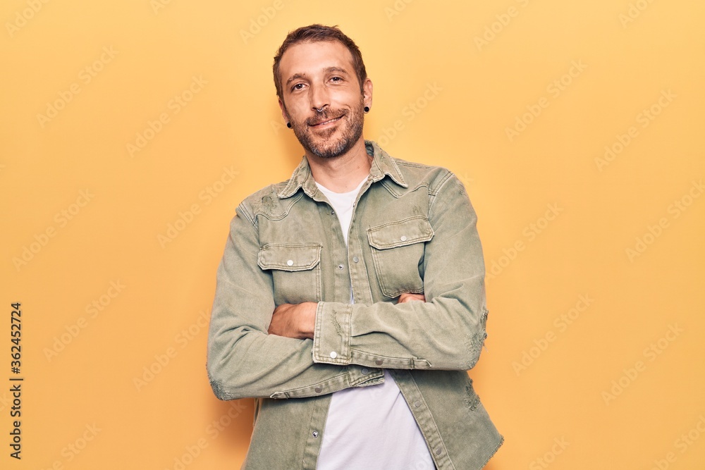 Young handsome man wearing casual clothes happy face smiling with crossed arms looking at the camera. positive person. Young handsome man wearing casual clothes happy face smiling with crossed arms looking at the camera. positive person.