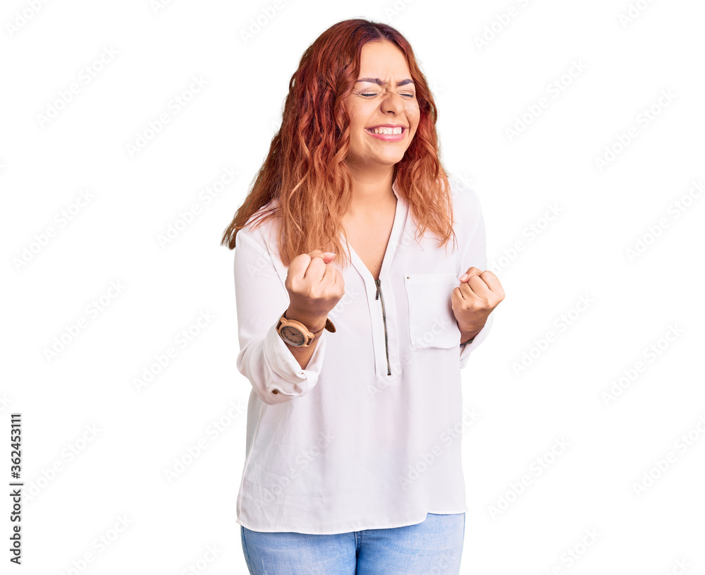Young latin woman wearing casual clothes very happy and excited doing winner gesture with arms raised, smiling and screaming for success. celebration concept. Young latin woman wearing casual clothes very happy and excited doing winner gesture with arms raised, smiling and screaming for success. celebration concept.