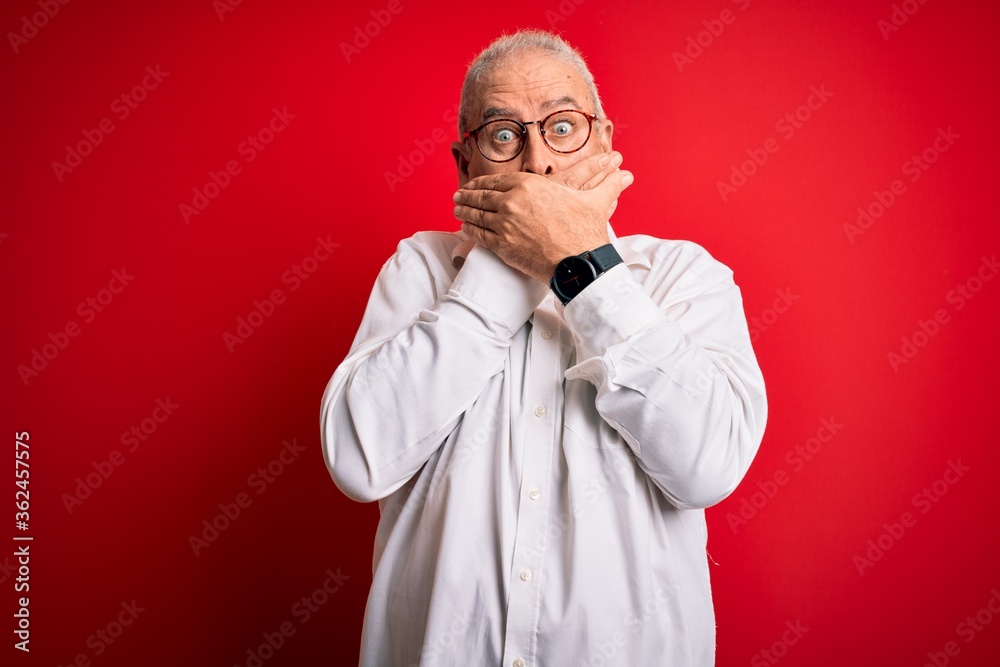 Middle age handsome hoary man wearing casual shirt and glasses over red background shocked covering mouth with hands for mistake. Secret concept. Middle age handsome hoary man wearing casual shirt and glasses over red background shocked covering mouth with hands for mistake. Secret concept.