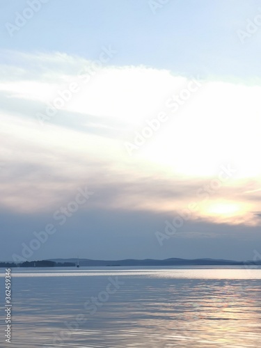 River horizon sunset landscape. Industrial pond in Yekaterinburg  Iset river in summer with sun and clouds reflection in water