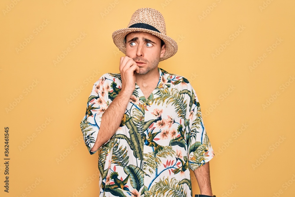 Young handsome man with blue eyes on vacation wearing summer florar shirt and hat looking stressed and nervous with hands on mouth biting nails. Anxiety problem. Young handsome man with blue eyes on vacation wearing summer florar shirt and hat looking stressed and nervous with hands on mouth biting nails. Anxiety problem.
