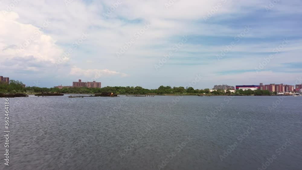 Low flying drone flies quickly over the ocean toward a wooded landmass. Low flying drone flies quickly over the ocean toward a wooded landmass.