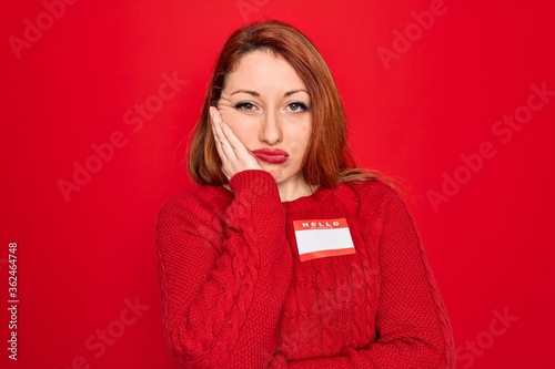 Young beautiful redhead woman wearing sticker presentation with hello my name message thinking looking tired and bored with depression problems with crossed arms.