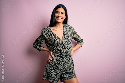 Young beautiful woman wearing fashion urban clothes, model wearing casual street style standing over pink background