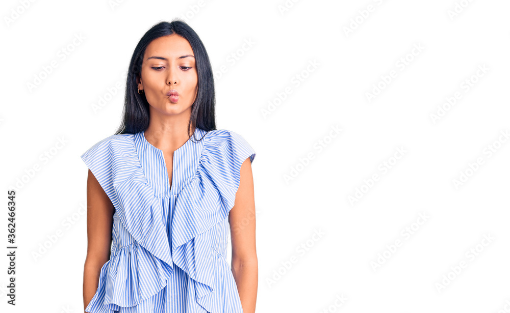 Young beautiful latin girl wearing casual clothes making fish face with lips, crazy and comical gesture. funny expression. Young beautiful latin girl wearing casual clothes making fish face with lips, crazy and comical gesture. funny expression.