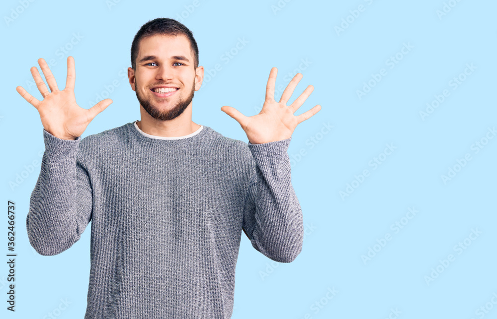 Young handsome man wearing casual sweater showing and pointing up with fingers number ten while smiling confident and happy. Young handsome man wearing casual sweater showing and pointing up with fingers number ten while smiling confident and happy.