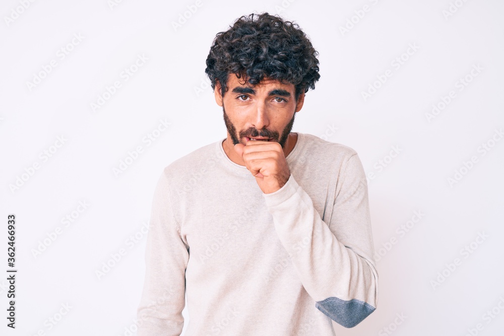 Handsome young man with curly hair and bear wearing casual winter sweater feeling unwell and coughing as symptom for cold or bronchitis. health care concept. Handsome young man with curly hair and bear wearing casual winter sweater feeling unwell and coughing as symptom for cold or bronchitis. health care concept.