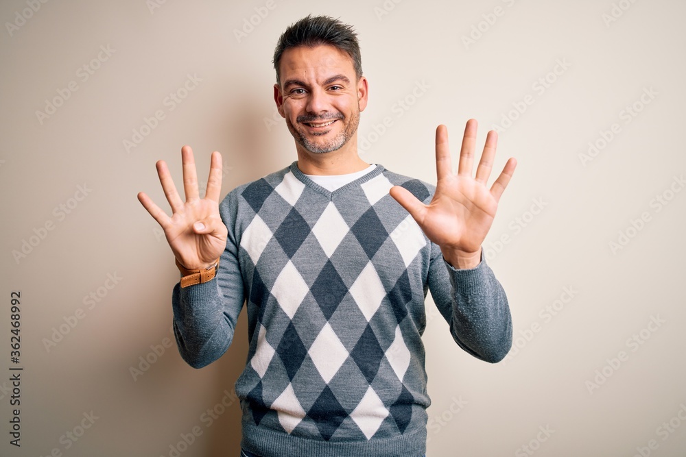 Young handsome man wearing casual sweater standing over isolated white background showing and pointing up with fingers number nine while smiling confident and happy. Young handsome man wearing casual sweater standing over isolated white background showing and pointing up with fingers number nine while smiling confident and happy.
