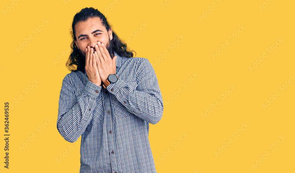 Young arab man wearing casual clothes laughing and embarrassed giggle covering mouth with hands, gossip and scandal concept Young arab man wearing casual clothes laughing and embarrassed giggle covering mouth with hands, gossip and scandal concept