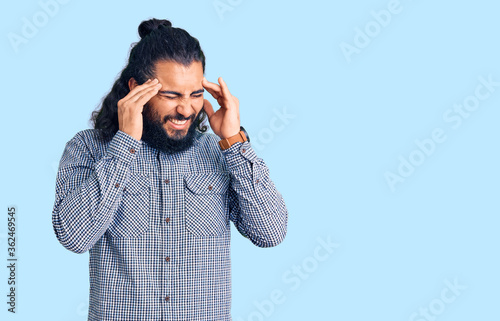 Young arab man wearing casual clothes with hand on head, headache because stress. suffering migraine.