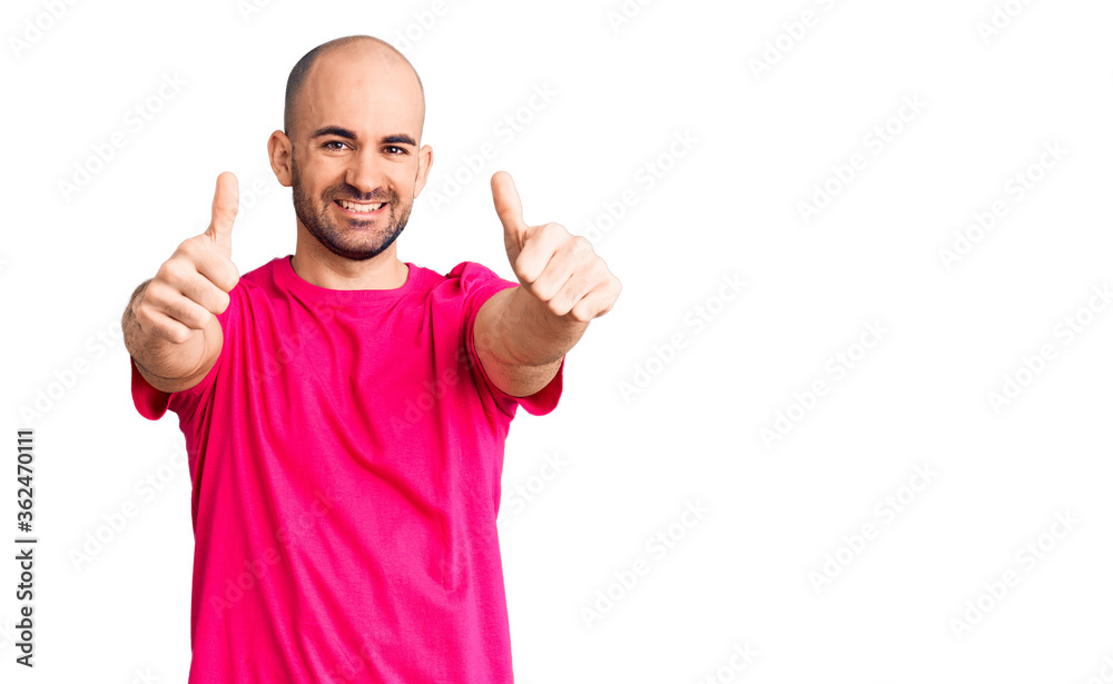 Young handsome man wearing casual t shirt approving doing positive gesture with hand, thumbs up smiling and happy for success. winner gesture. Young handsome man wearing casual t shirt approving doing positive gesture with hand, thumbs up smiling and happy for success. winner gesture.