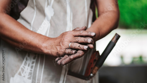 Hand of a man after take care of his garden.Image of dirty hands with soil or stain of a farmer or homemaker with gardening tools.Chill out time while gardening.Simple slow life concept.
