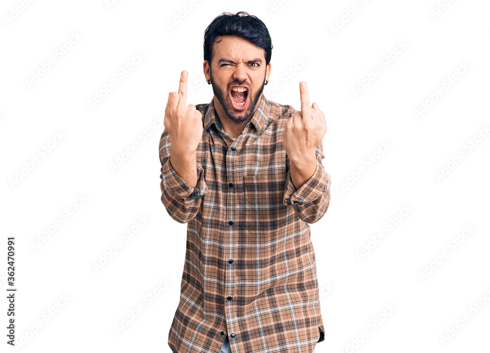 Naklejka premium Young hispanic man wearing casual clothes showing middle finger doing fuck you bad expression, provocation and rude attitude. screaming excited