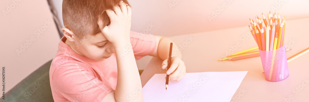 Little boy drawing. Closed Locking Exercise. Homemade routine. School lessons. Write pencil on piece of paper. Home study. Elementary preschool. Male kid student. Thinking or dreaming. Horizontal Little boy drawing. Closed Locking Exercise. Homemade routine. School lessons. Write pencil on piece of paper. Home study. Elementary preschool. Male kid student. Thinking or dreaming. Horizontal