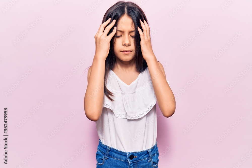 Beautiful child girl wearing casual clothes with hand on head, headache because stress. suffering migraine. Beautiful child girl wearing casual clothes with hand on head, headache because stress. suffering migraine.