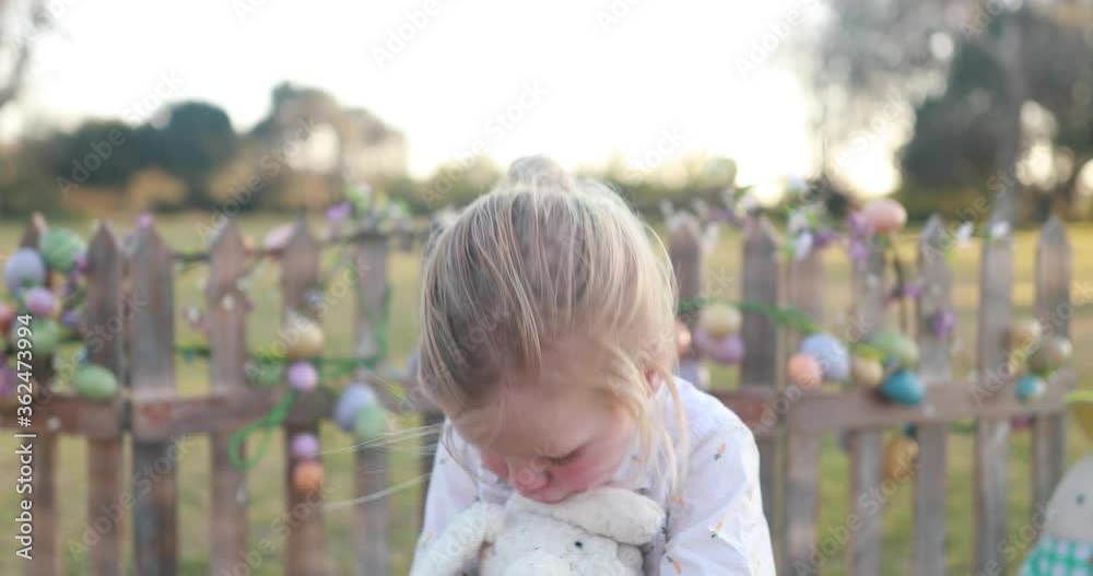 A young boy wearing Easter themed attire smiles and hugs his stuffed bunny rabbit. A young boy wearing Easter themed attire smiles and hugs his stuffed bunny rabbit.