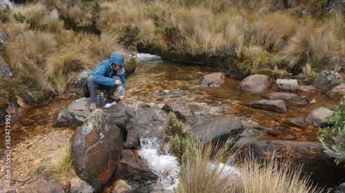 Refilling water bottle in the Andes mountains, santa cruz trek peru. photo