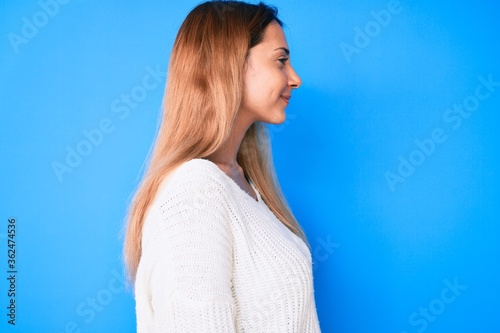 Young brunette woman wearing casual sweater looking to side, relax profile pose with natural face with confident smile. © Krakenimages.com