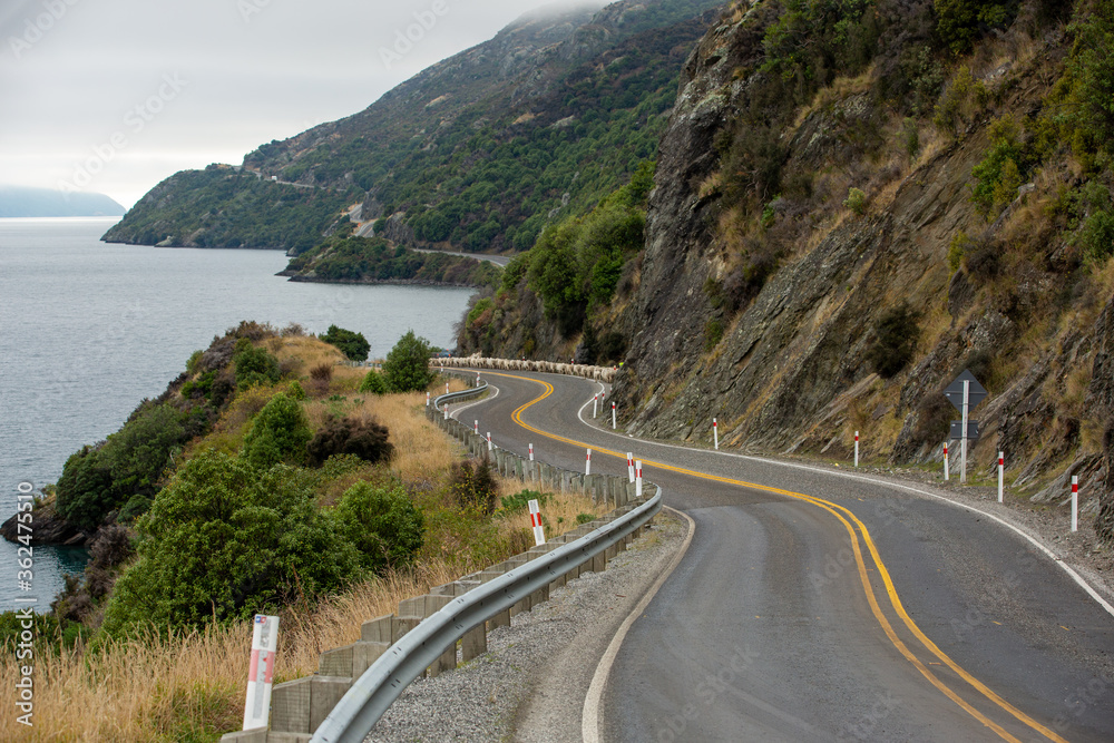 Beautiful road with cloudy sky along Lake Wakatipu, Queenstown, New Zealand.