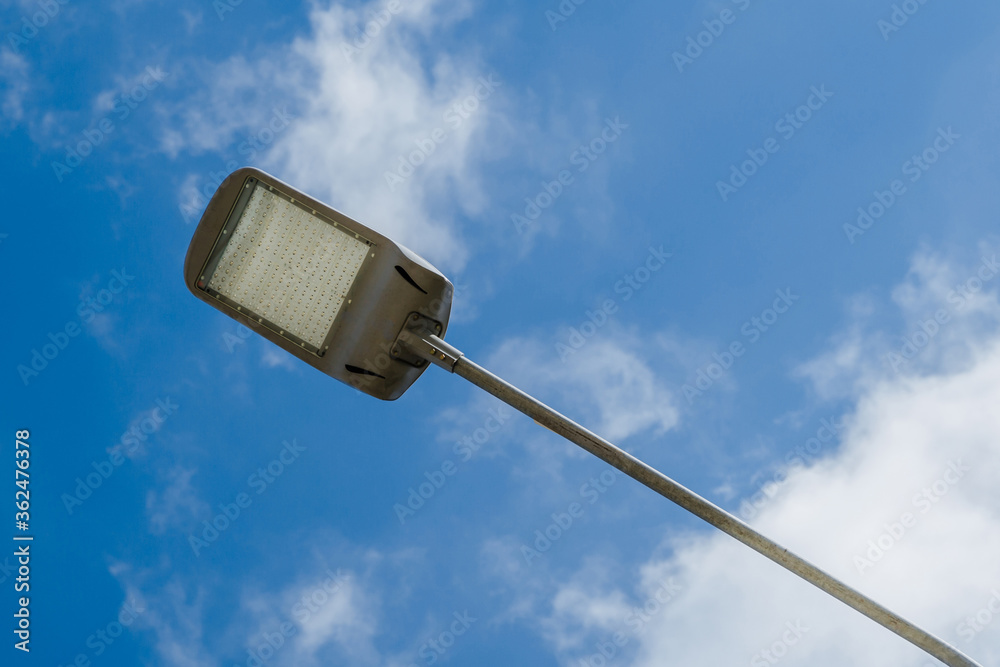 Street lantern on sky with white clouds background.A modern street LED lighting pole. Street lantern on sky with white clouds background.A modern street LED lighting pole.