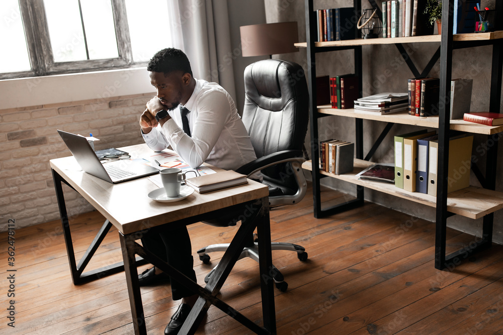 Handsome african business man have video call with сolleagues using laptop in modern office Handsome african business man have video call with сolleagues using laptop in modern office