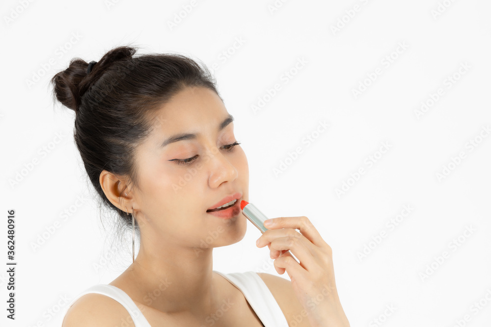 Healthy and cosmetics concept. Beauty face of young Asian woman applying make up with lipstick over white isolated background. Healthy and cosmetics concept. Beauty face of young Asian woman applying make up with lipstick over white isolated background.