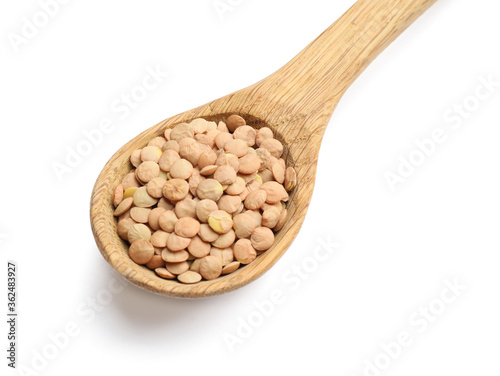 Raw lentils in spoon on white background