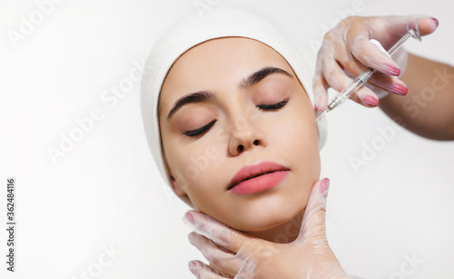 Cosmetology treatment in a clinic or beauty salon. Close-up face injection for a young woman. Beautician at work. The concept of perfect smooth clean skin and eternal youth