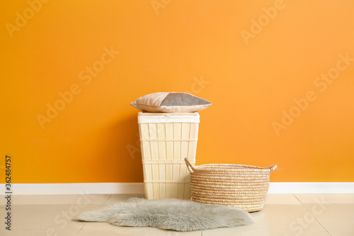 Different wicker baskets near color wall