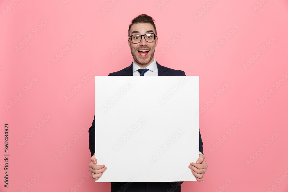 happy elegant businessman holding empty board and smiling happy elegant businessman holding empty board and smiling