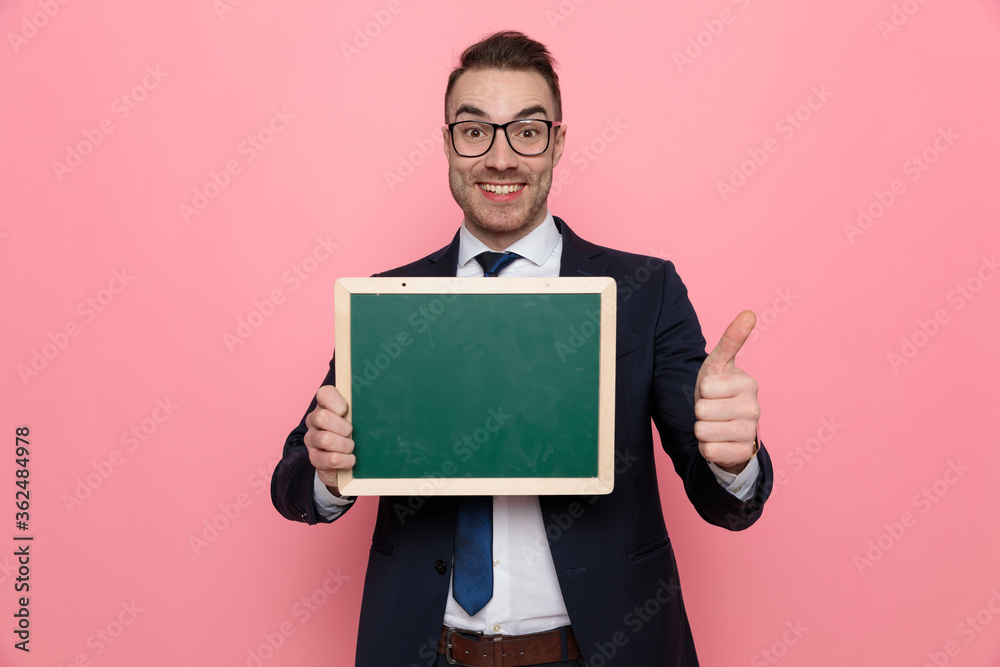 happy elegant guy holding blackboard and making thumbs up sign happy elegant guy holding blackboard and making thumbs up sign