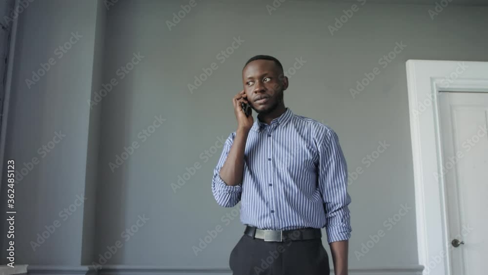 Young successful black businessman using phone, good news excited happy cheerful smiling. Success and achievement concept Young successful black businessman using phone, good news excited happy cheerful smiling. Success and achievement concept