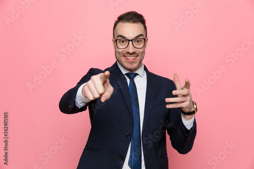happy young elegant man smiling and pointing finger