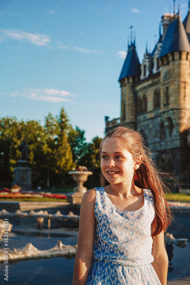 Portrait of a Little girl child lover of fairy tales on the background of a medieval castle with flowers