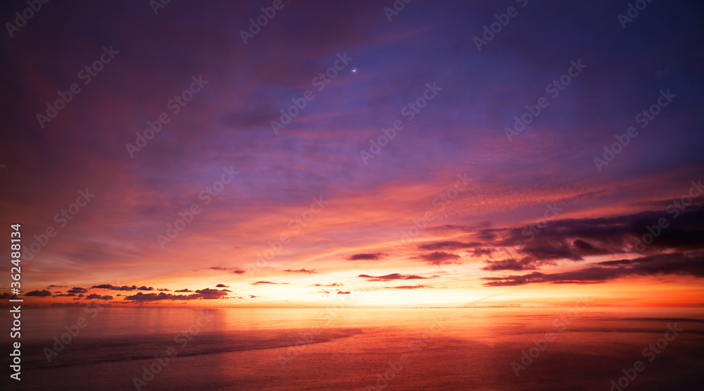 Landscape Long exposure of majestic clouds in the sky sunset or sunrise over sea with reflection in the tropical sea.