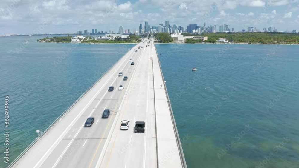 4K drone shot of cars driving above the beautiful clear blue waters in Miami downtown direction, Florida, USA. Beautiful aerial view of the automotive bridge over the Atlantic ocean bay at sunny day. 4K drone shot of cars driving above the beautiful clear blue waters in Miami downtown direction, Florida, USA. Beautiful aerial view of the automotive bridge over the Atlantic ocean bay at sunny day.