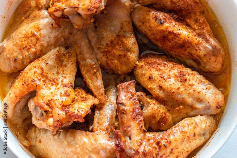 Grilled chicken wings with spices in a white bowl on the table, top view, flat lay Grilled chicken wings with spices in a white bowl on the table, top view, flat lay