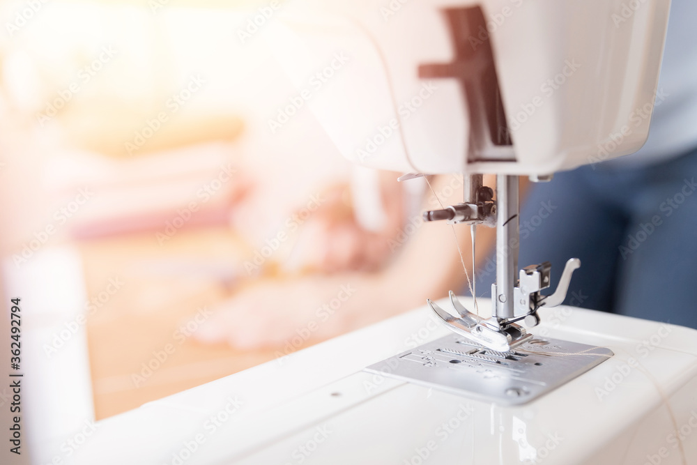 Workplace of seamstress tailor. Young female designer cuts out pattern of fabric from sketch line with scissors for tailoring dresses and clothes