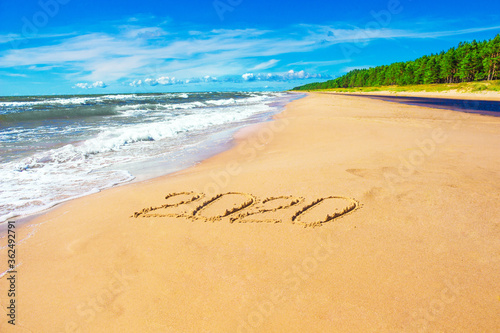 Romantic coastline with number 2020 on sand