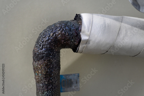 Buildup of water condensation on old rusty refrigerant suction line pipe  photo