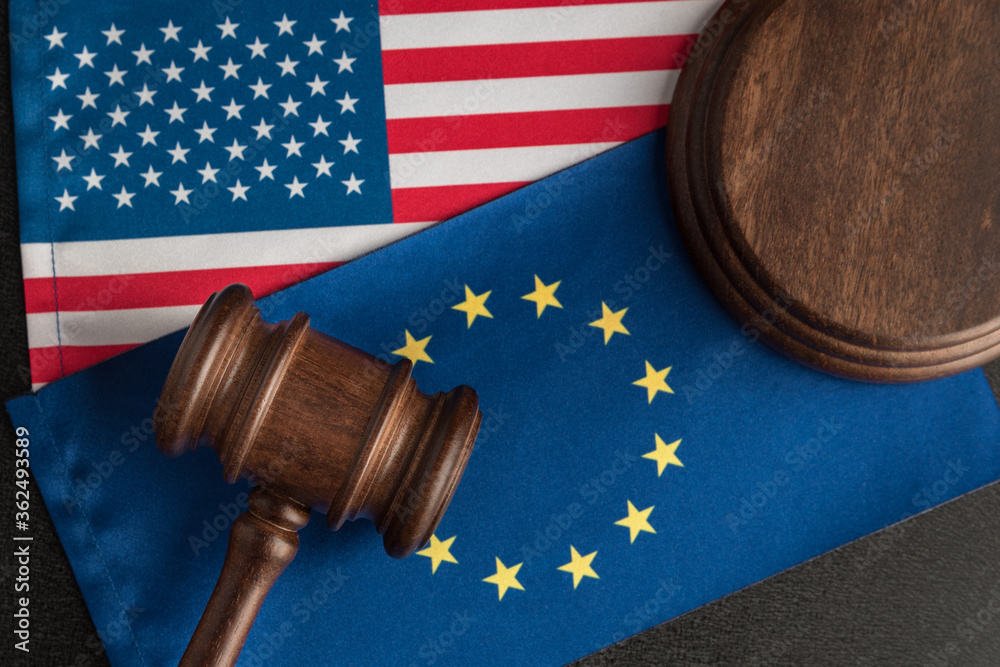 Judge gavel over US flag and EU. Legal confrontation United States of America and European Union