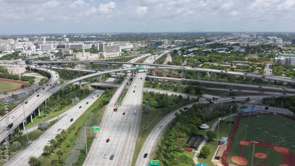 4k slow motion of cars transportation by the busy highway at rush hour. Aerial of traffic with freeway panorama. Drone flight over multi-level intersection on sunny day. Beautiful Miami city, USA 4k slow motion of cars transportation by the busy highway at rush hour. Aerial of traffic with freeway panorama. Drone flight over multi-level intersection on sunny day. Beautiful Miami city, USA