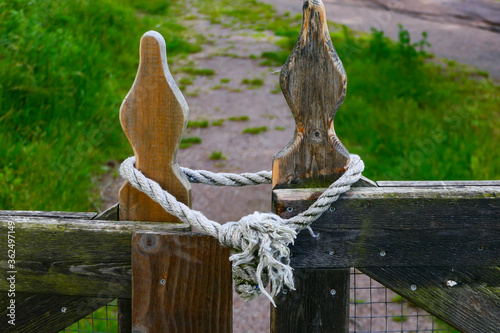 Lidkoping, Sweden  A wooden gate and rope lock in a field. photo