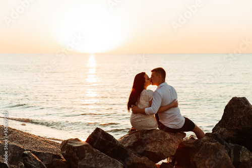 Loving couple in white clothes during a honeymoon at sea walk on the sand at a photoshoot Love Story, ocean coast, beach © Олег Блохин