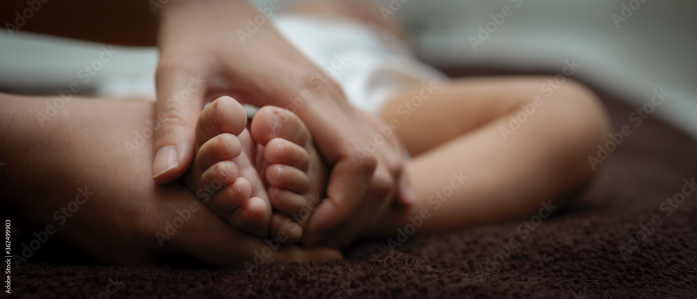 Close up view of parent hands holding tiny feet newborn baby Close up view of parent hands holding tiny feet newborn baby