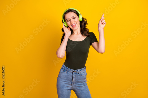 Portrait of her she nice attractive lovely cheerful cheery wavy-haired girl listening music dancing moving party rhythm isolated on bright vivid shine vibrant yellow color background
