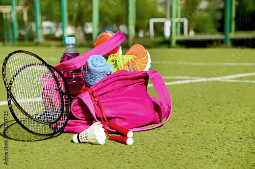 Bag with sports equipment on the sports courts background in the sunny day.